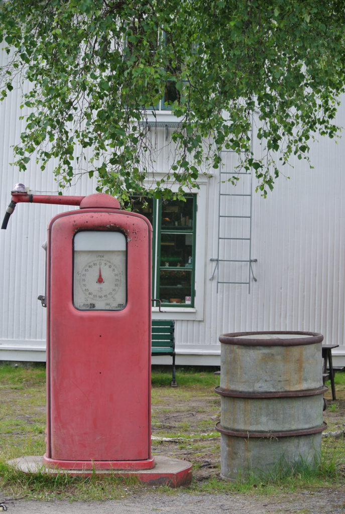 Alte Tankstellenzapfanlage neben einem alten Ölfass